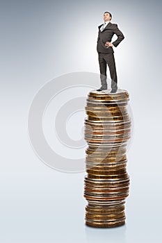 Businessman on coins pile