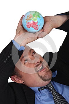 Businessman collapsing under globe