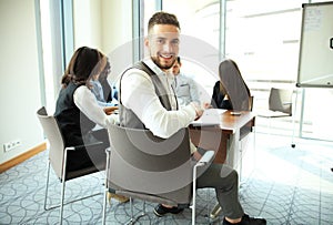 Businessman with colleagues in the background in office.