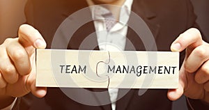 Businessman collects puzzles with the words Team management. Increase efficiency. Hiring and dismissal employees. Organization of