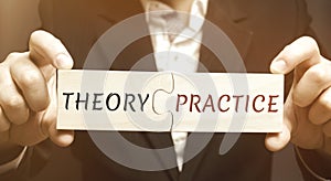 A businessman collects wooden puzzles with the word Theory and Practice. Obtaining information and application it in practice.