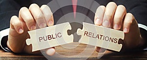Businessman collects wooden puzzles with the words Public Relations. Management of information flows between the organization and
