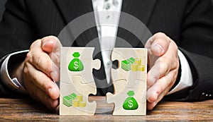 Businessman combines money puzzles. Fundraising, attracting investments for the implementation of business projects and startups photo