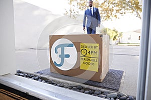 Businessman Coming Home To Fresh Food Home Delivery In Cardboard Box Outside Front Door