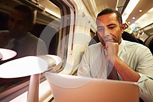 Businessman Commuting To Work On Train And Using Laptop photo