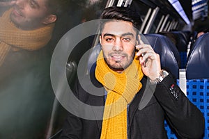 Businessman commuting to work on train using phone
