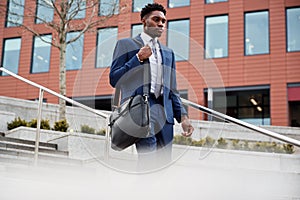 Businessman Commuting To Work Walking Down Steps To Railway Station