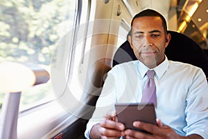 Businessman Commuting On Train Reading A Book