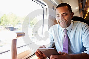 Businessman Commuting On Train Reading A Book