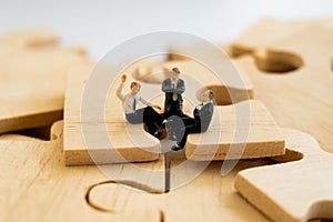 Businessman concept sit on the jigsaw puzzle meaning of key success