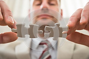 Businessman connecting together puzzle