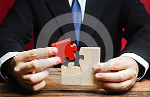 Businessman connects a red puzzle to the assembly. Business model planning and strategy, building a new one. Innovation photo