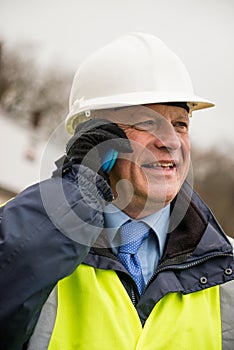 Businessman construction worker using mobile phone.