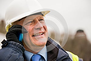 Businessman construction worker using mobile phone.