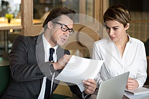 Businessman consulting with female colleague on contract conditi