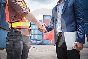 Businessman and Container Shipping Worker Handshake Together for Cooperation Shipment in Logistic Warehouse, Business Partnership
