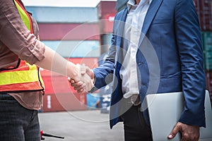 Businessman and Container Shipping Worker Handshake Together for Cooperation Shipment in Logistic Warehouse, Business Partnership
