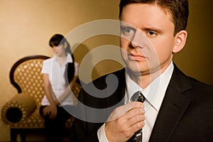 Businessman correcting tie and beautiful brunette