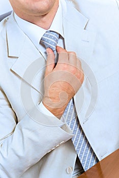 Businessman corrects a tie themselves