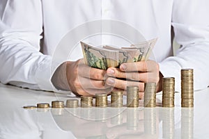 Businessman Counting Money At Desk