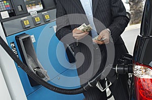 Businessman Counting Money At Fuel Station