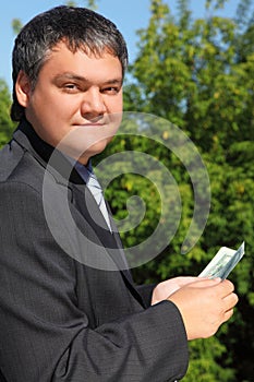 Businessman counting money outdoor in summer photo