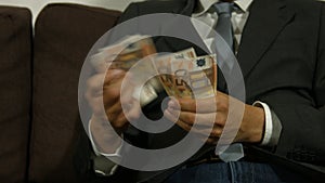 Businessman counting money and puts them in his pocket