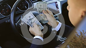 Businessman Counting Money Usd Bills Payday Inside Car. Man sitting with cash money at vehicle