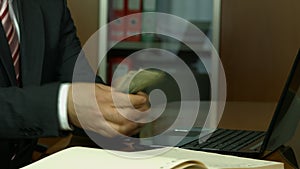 Businessman counting money and writing info