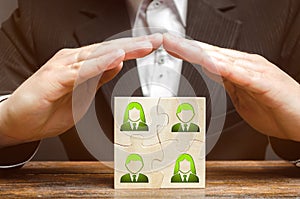 Businessman covers with hands the business team of employees. Patronage support, encouragement, privilege and financial aid. photo