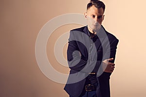 Businessman with crossed arms pose against beige background