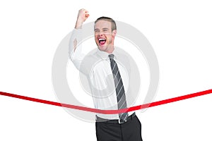 Businessman crossing the finish line while clenching fist