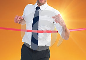 Businessman crossing finish line at dusk