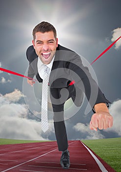 Businessman crossing finish line during race