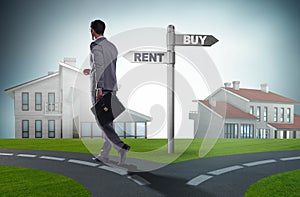 Businessman at crossroads betweem buying and renting