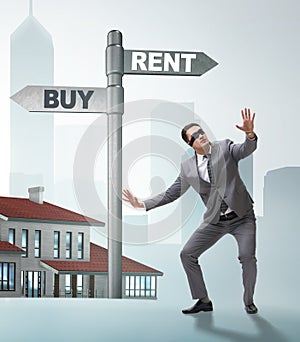 Businessman at crossroads betweem buying and renting