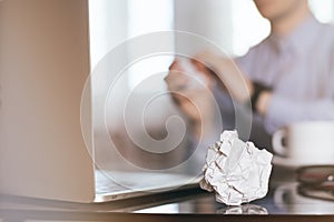 Businessman crumpling paper on his workplace.Office workplace with crumpled paper balls on the table