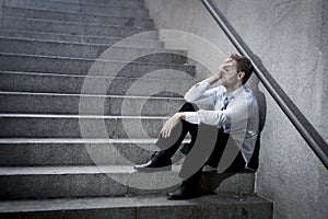 Businessman crying lost in depression sitting on street concrete stairs