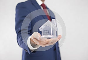 Businessman with crystal house in hand