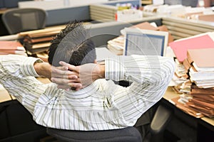 Businessman in cubicle with laptop