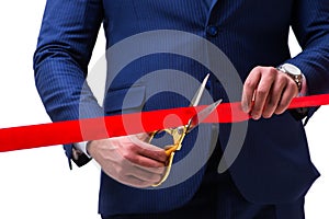The businessman cutting red ribbon isolated on white