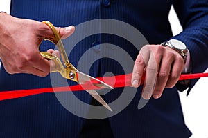 The businessman cutting red ribbon isolated on white