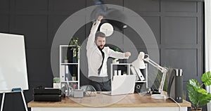 Businessman dancing and throwing his coat at office