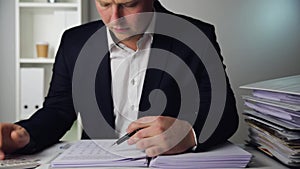 Businessman in a dark blue suit calculating sales results. Finance accounting concept