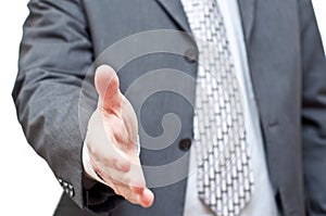 Businessman in dark suit extending hand to shake