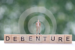 Businessman and debenture word on natural green background, Investments and Debenture concept photo