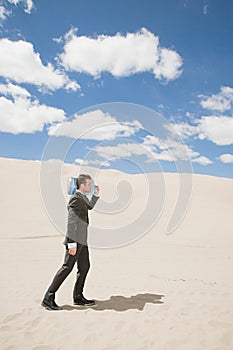 Businessman in desert with bottle