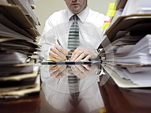 Businessman at Desk with Piles of Files