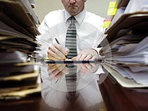 Businessman at Desk with Piles of Files