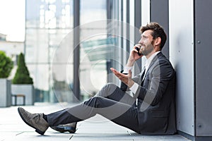 Businessman in despair reports bad news talking on the phone, depressed and sad, sitting at the office lost hope